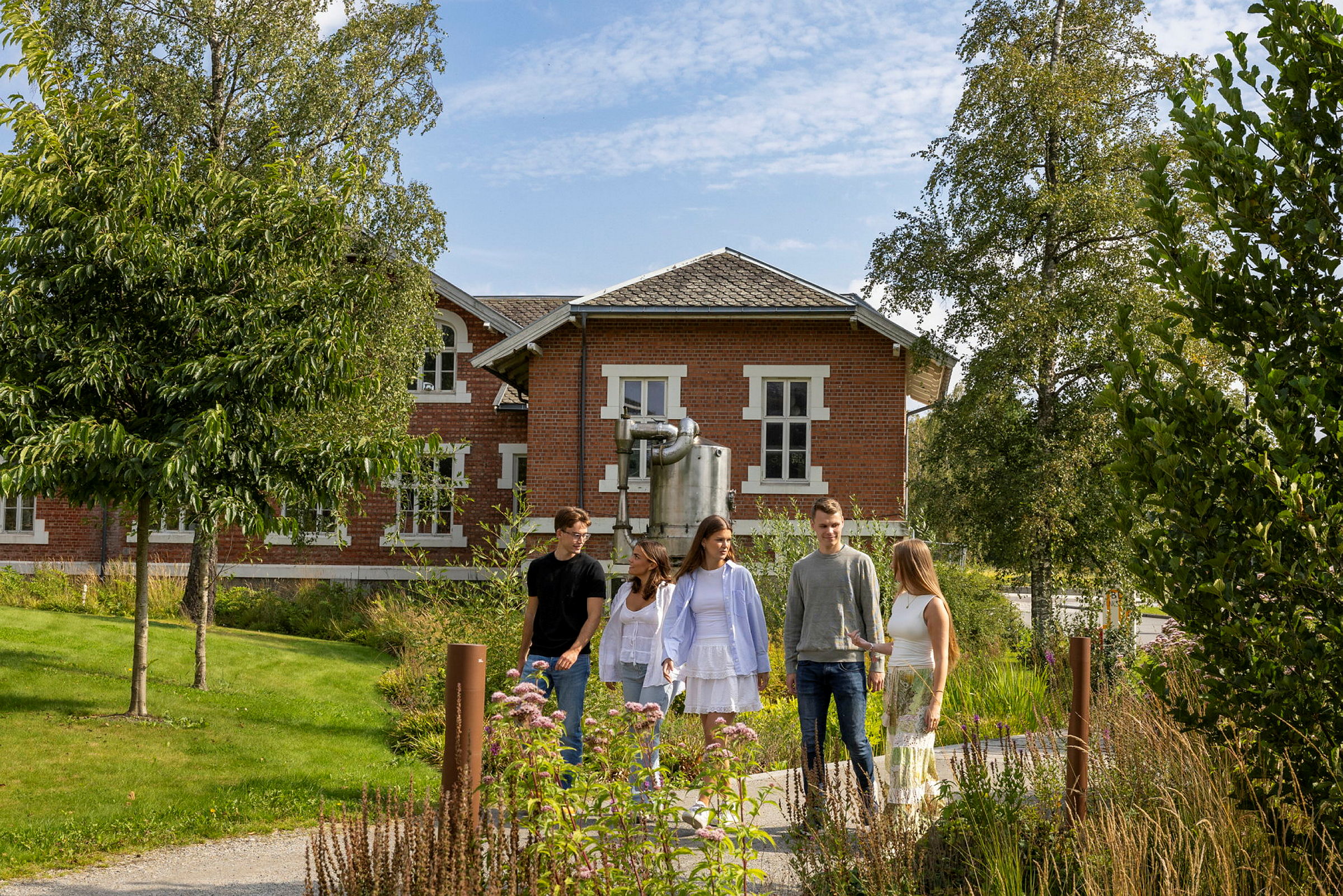 Fotografert august 2024.
Studentambassadører fotografert en augustdag på campus Ås, ved Storplenen, Universitetstunet, bak Meierimuseet og utenfor Audmax. 
Bildene er til bruk i rekruttering, og alle personene på bildene har gitt tillatelse til bruk.