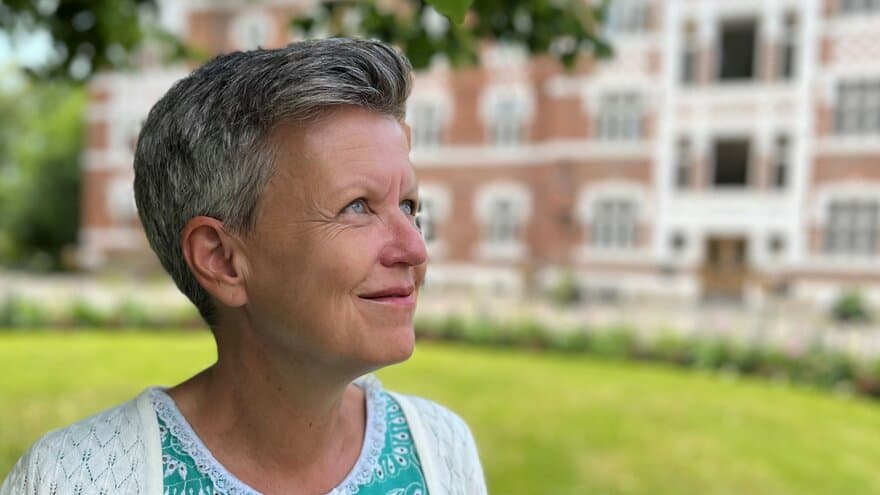 Professor Camilla Ihlebæk står under tuntreet på campus NMBU