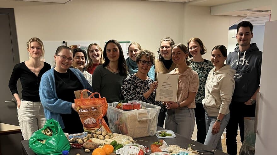Studentene i Foodsharing Ås er samlet for å lage mat og har akkurat fått studiemiljøprisen av prorektor for utdanning Elin Kubberød.
