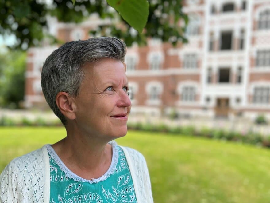 Professor Camilla Ihlebæk står under tuntreet på campus NMBU