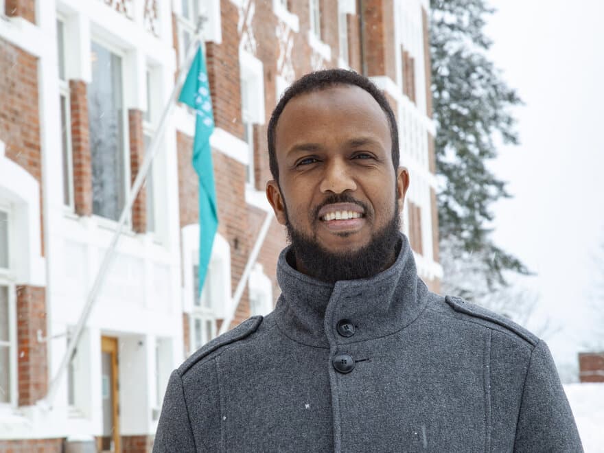 Gjennom sine gjøremål med renhold på NMBU så Farah Hassan Ibrahim så mye spennende på tavlene at han ble inspirert til å studere øknomi og administrasjon. 